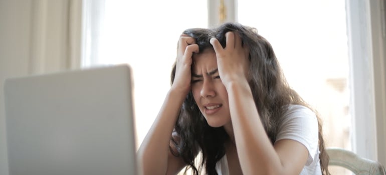 A woman using a laptop to research the connection between stress anxiety and substance use